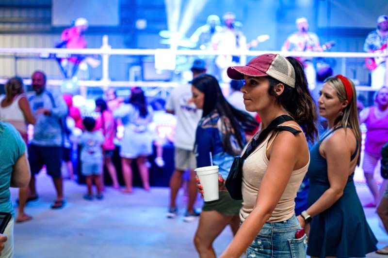 A woman is standing in front of a crowd of people at a party.
