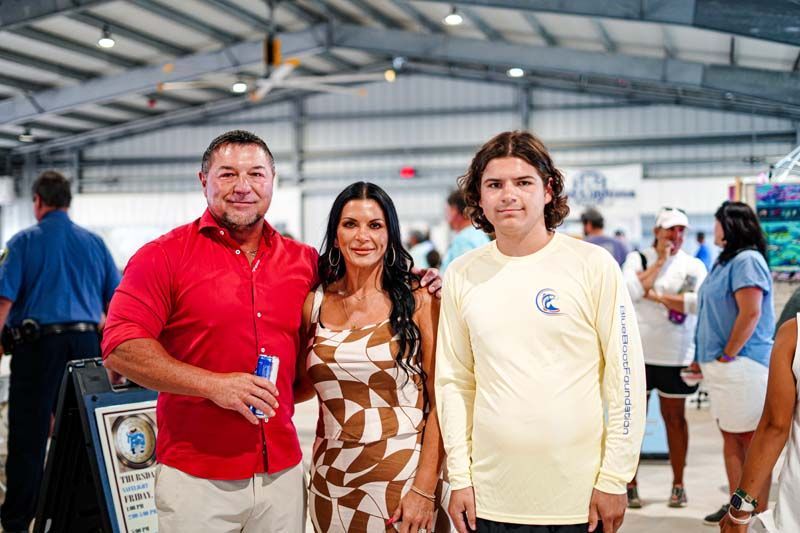 A man , a woman and a boy are posing for a picture in a building.