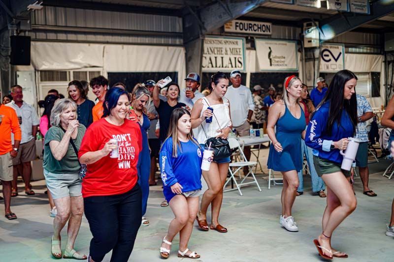 A group of people are dancing in front of a building.