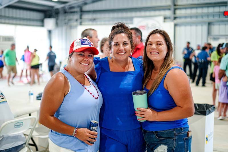 Three women are posing for a picture together in a room.