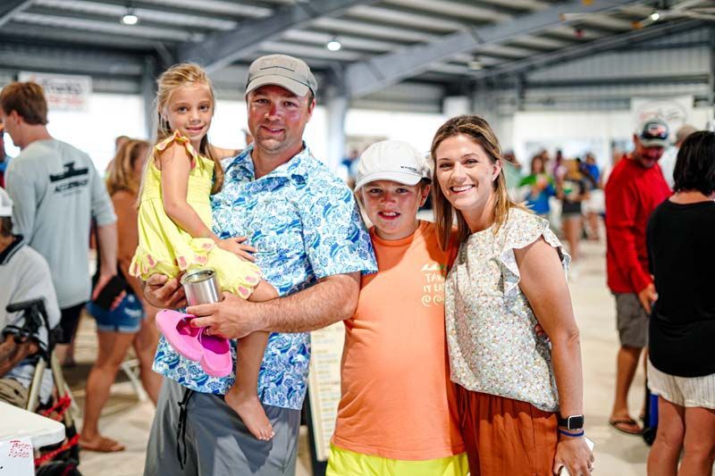 A family is posing for a picture in a crowded room.