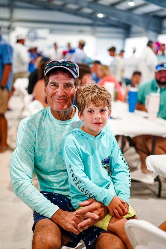 A man and a boy are sitting next to each other in a room.