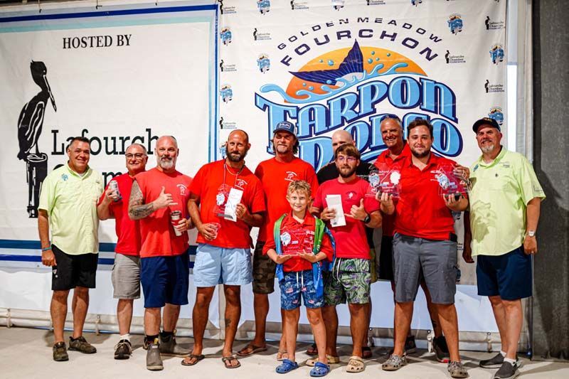 A group of men are posing for a picture in front of a banner.