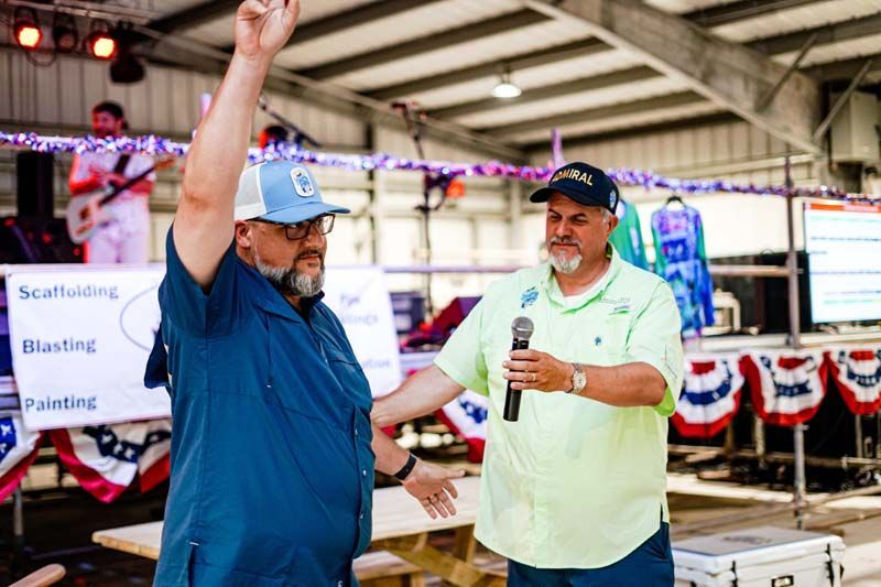 Two men are standing next to each other in a room holding microphones.