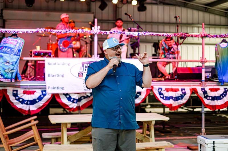 A man is standing on a stage talking into a microphone.