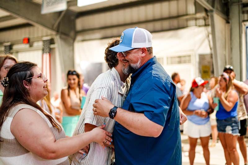A man and a woman are hugging each other in front of a crowd of people.