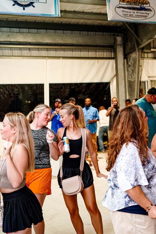 A group of people are standing in a room talking to each other.