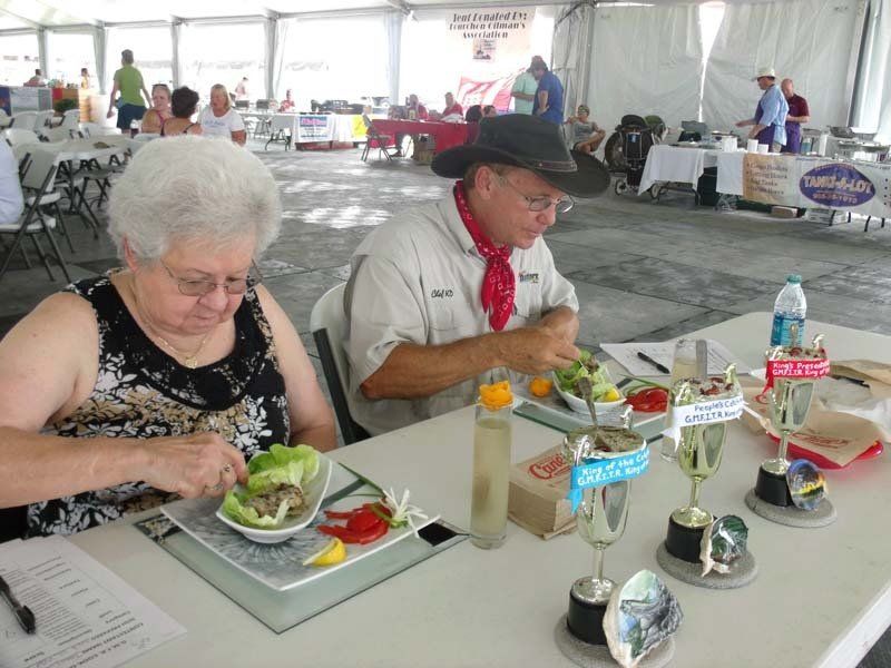A man and a woman are sitting at a table eating food