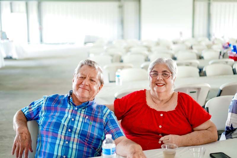 A man and a woman are sitting at a table in a room.