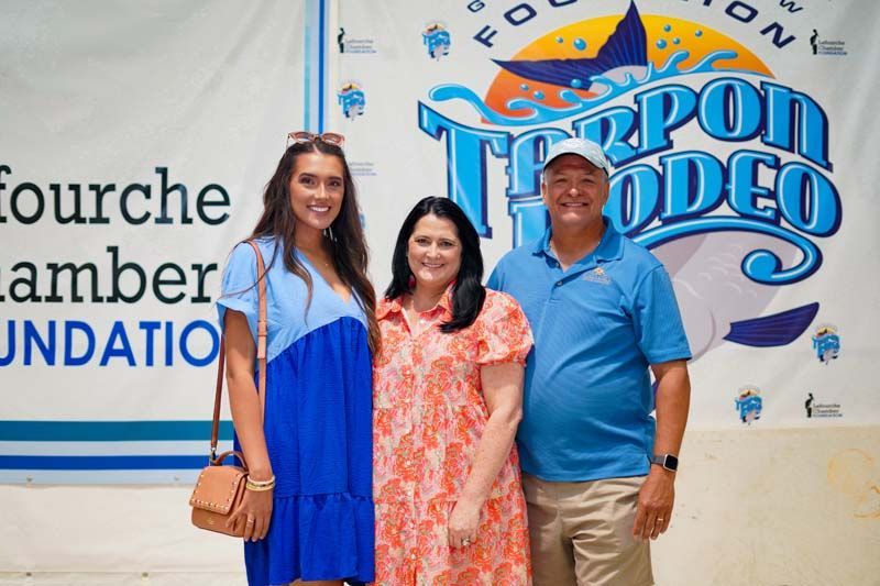 A group of people are posing for a picture in front of a sign that says fourche amber foundation.