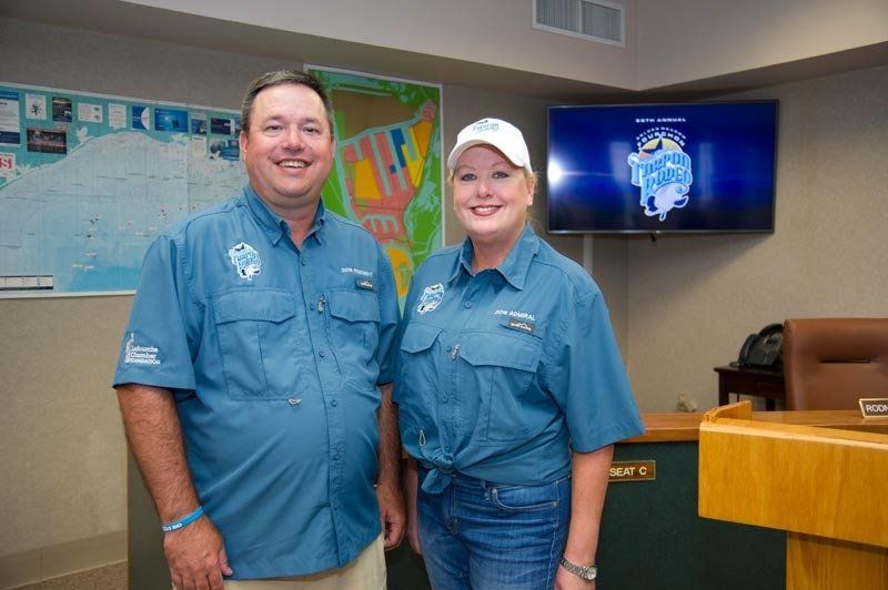 A man and a woman are standing next to each other in a room.