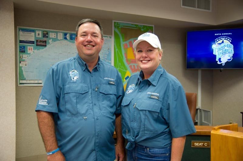 A man and a woman are standing next to each other in a room.