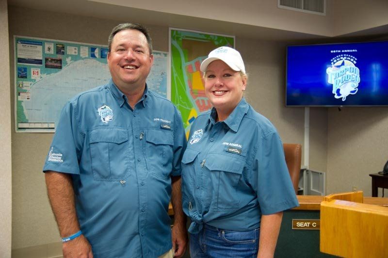 A man and a woman are standing next to each other in a room.