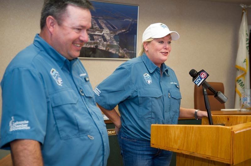 A man and a woman are standing behind a podium with a microphone on it
