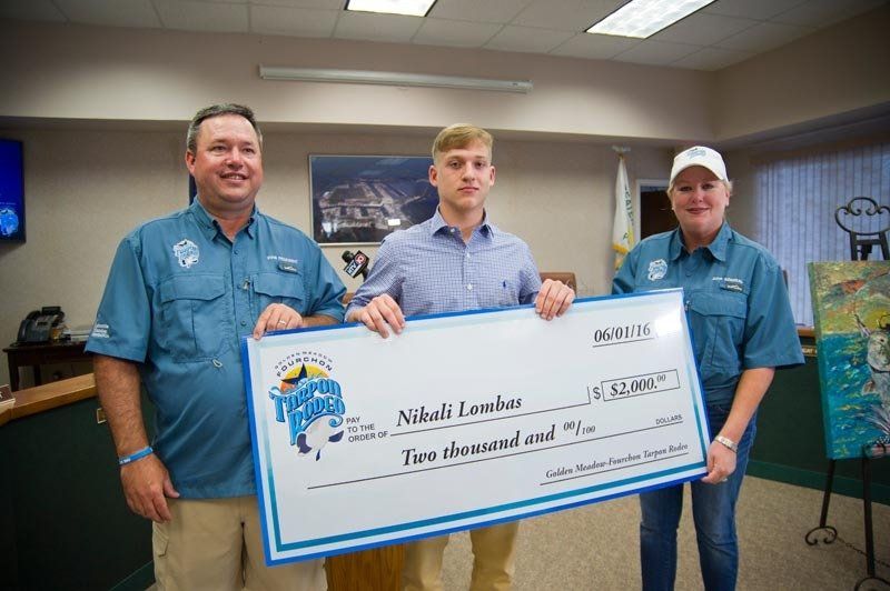 Three men are standing next to each other holding a large check.