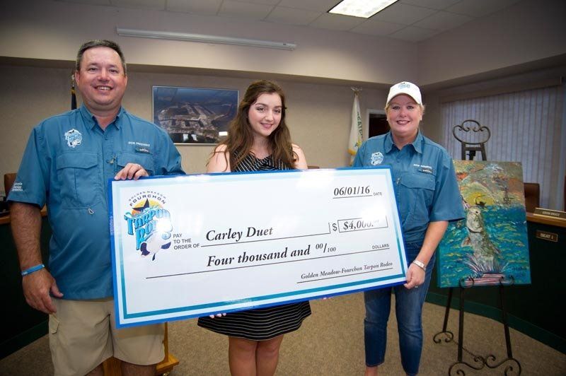 A man and two women are holding a large check.