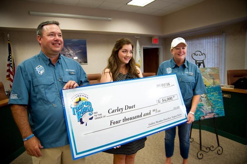 A man and two women are holding a large check.