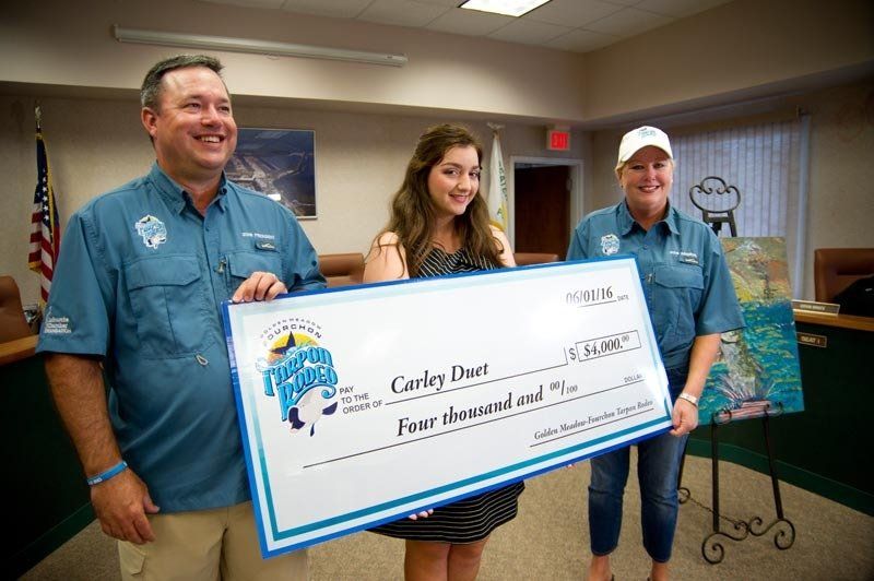 A man and two women are holding a large check.