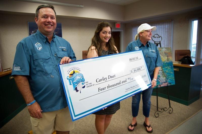 A man and two women are holding a large check.