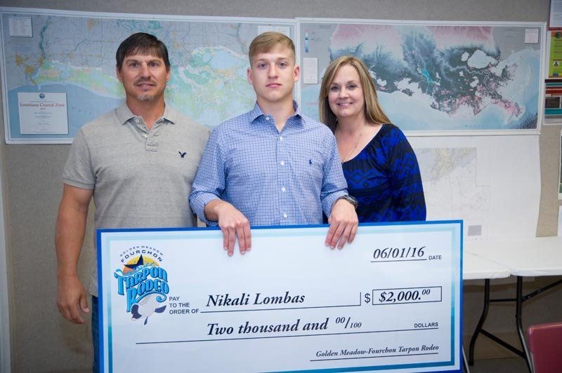 A man and woman are standing next to a young man holding a large check.