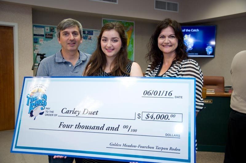 A man and two women holding a four thousand dollar check