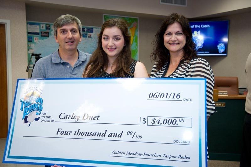 Three people holding a large cheque for four thousand dollars