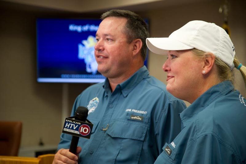 A man and a woman are standing next to each other holding microphones.