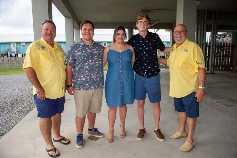 A group of people standing next to each other on a sidewalk.