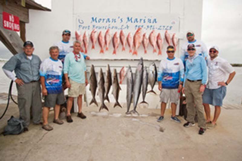 A group of men standing in front of a sign that says motan 's marina