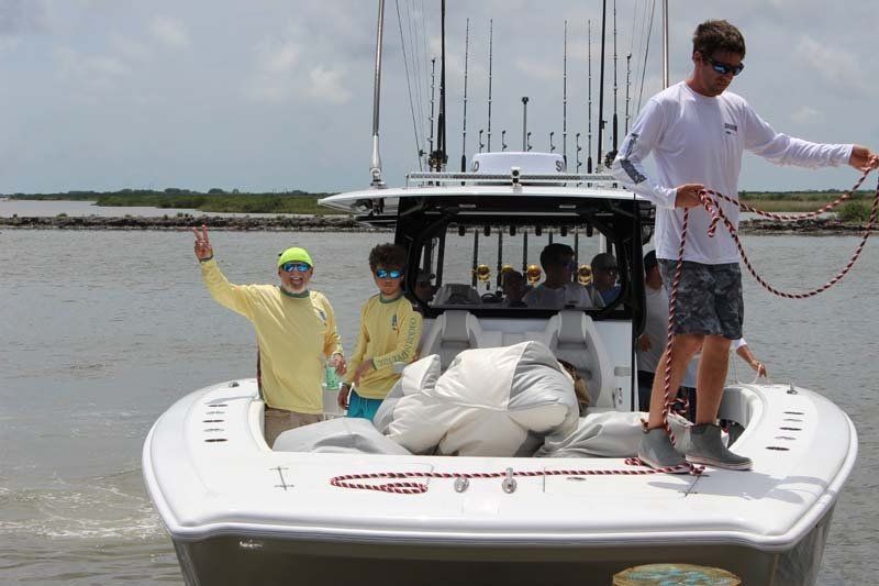 A group of people are standing on a boat in the water.