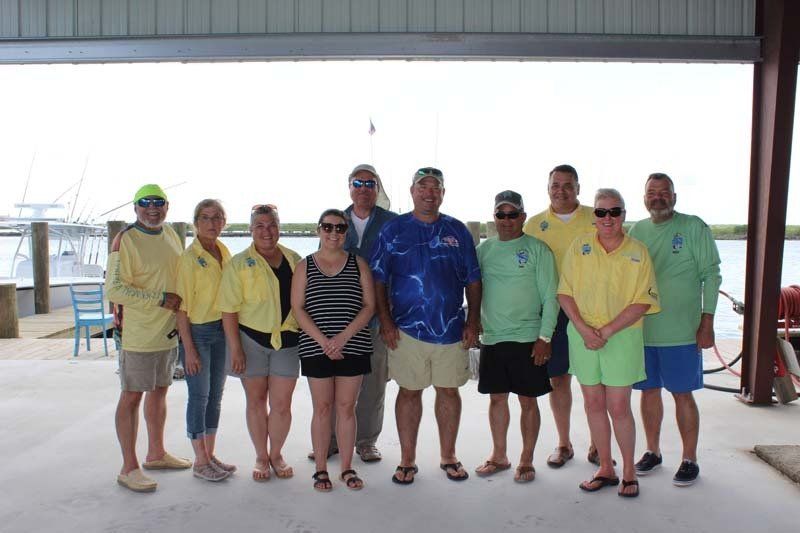 A group of people posing for a picture in front of a boat