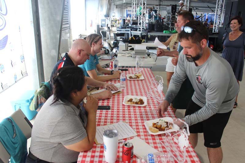 A group of people are sitting at a table with plates of food on it.