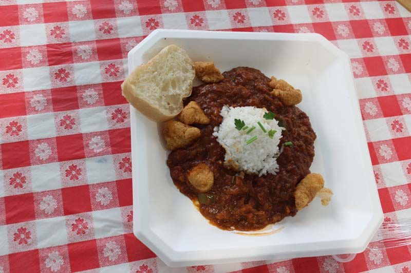 A plate of food with rice and bread on a checkered table cloth