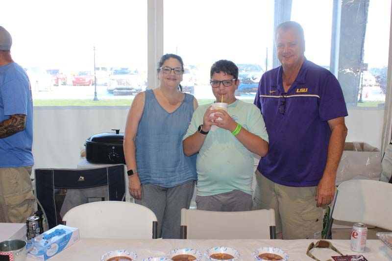 A group of people are standing around a table drinking coffee.