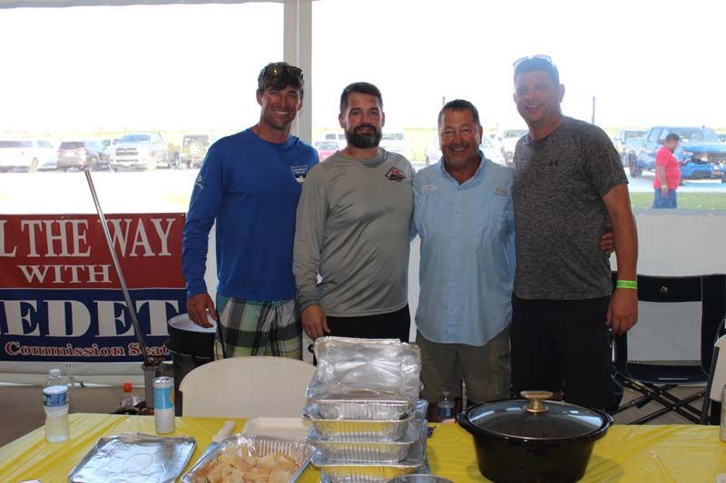 Four men are posing for a picture in front of a sign that says ' i the way with eidet '