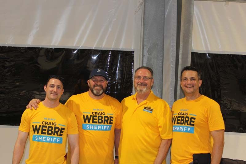 Four men wearing yellow webre sheriff shirts are posing for a picture.