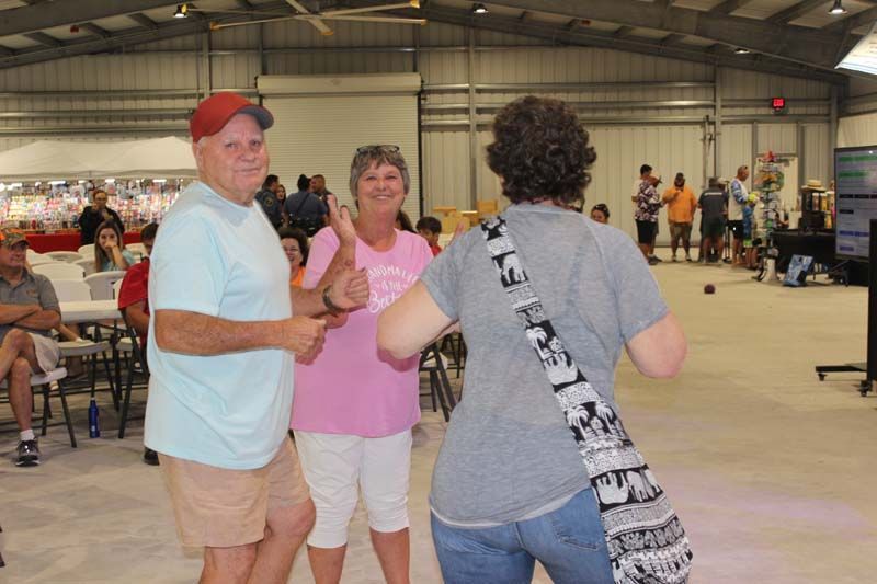 A group of people are dancing in a large room.