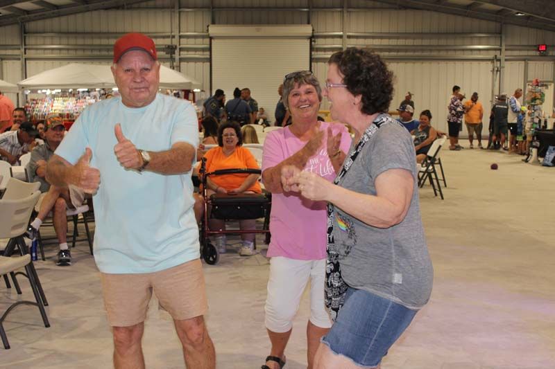 A group of people are dancing together in a large room.