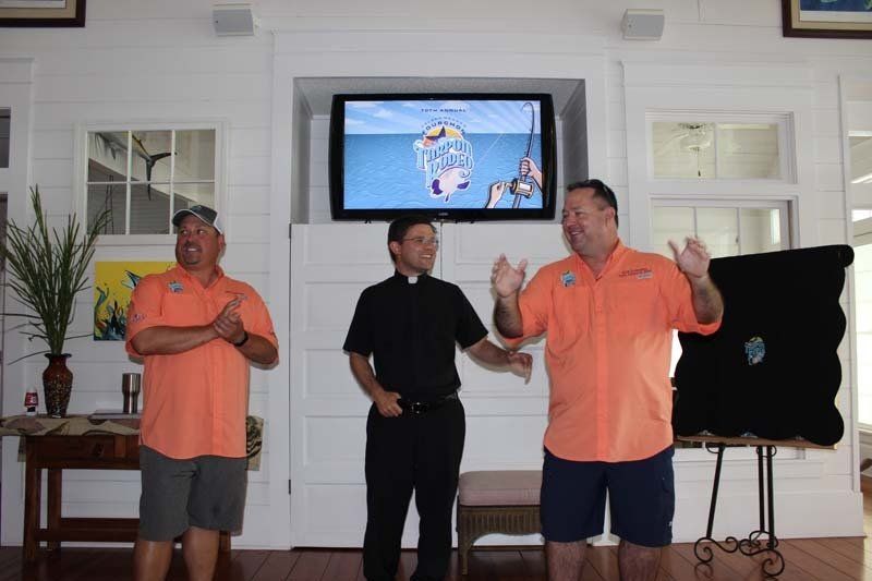 Three men standing in front of a flat screen tv