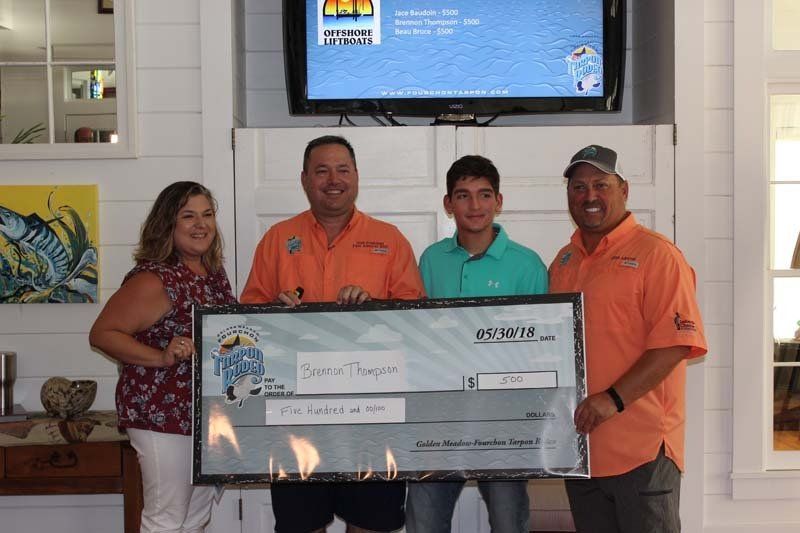 A group of people standing next to each other holding a large check.