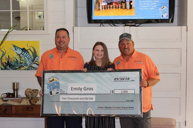 Two men and a woman are holding a large check.