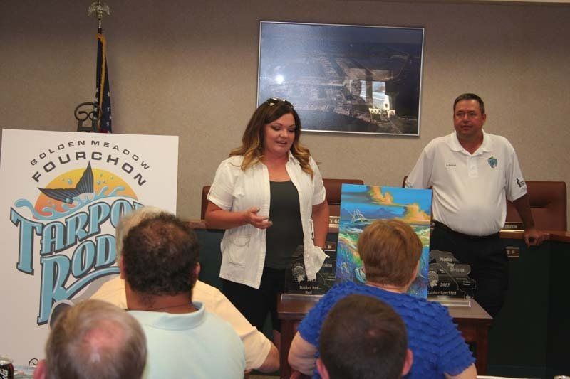 A woman stands in front of a sign that says fourchon