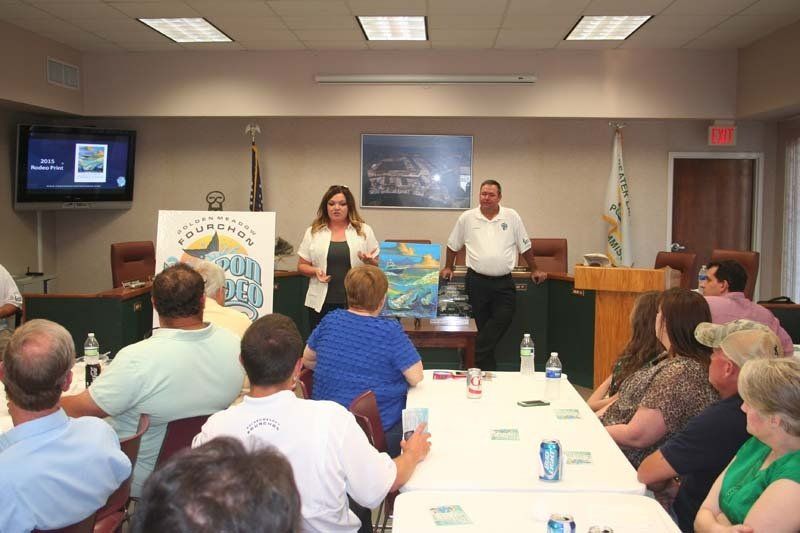 A woman is giving a presentation to a group of people sitting around a table