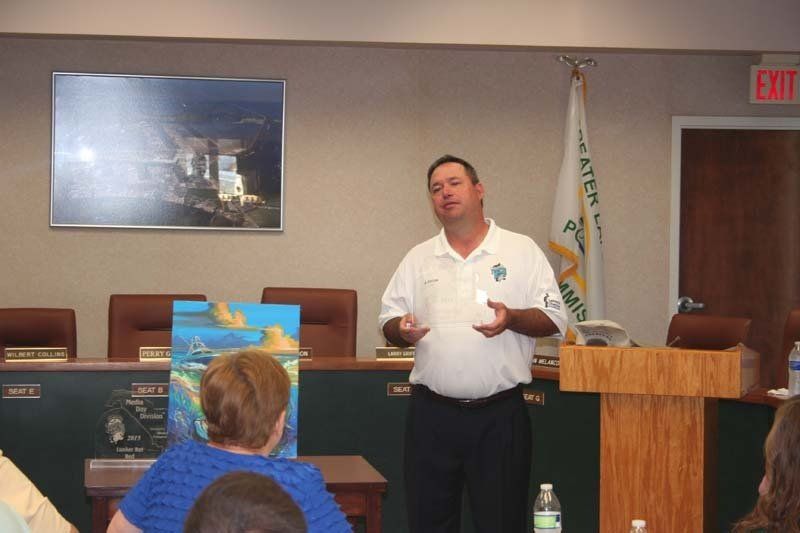 A man stands at a podium giving a presentation to a group of people
