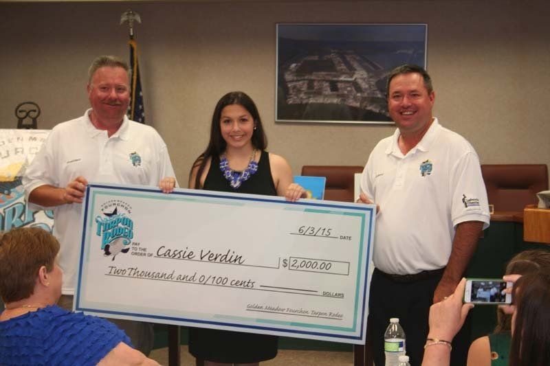 Two men and a woman are holding a large cheque for $ 15,000