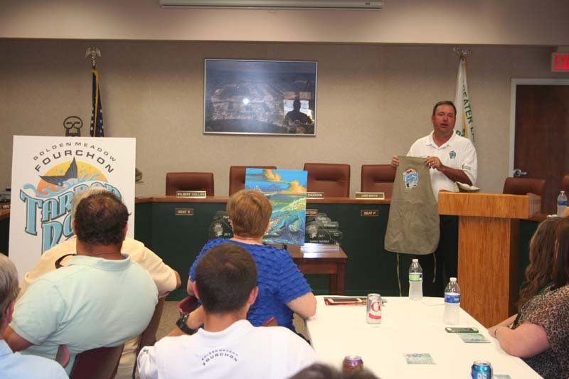 A man stands at a podium giving a presentation to a group of people