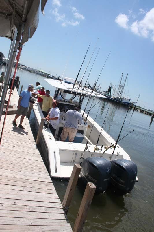 A group of people standing on a dock next to a boat