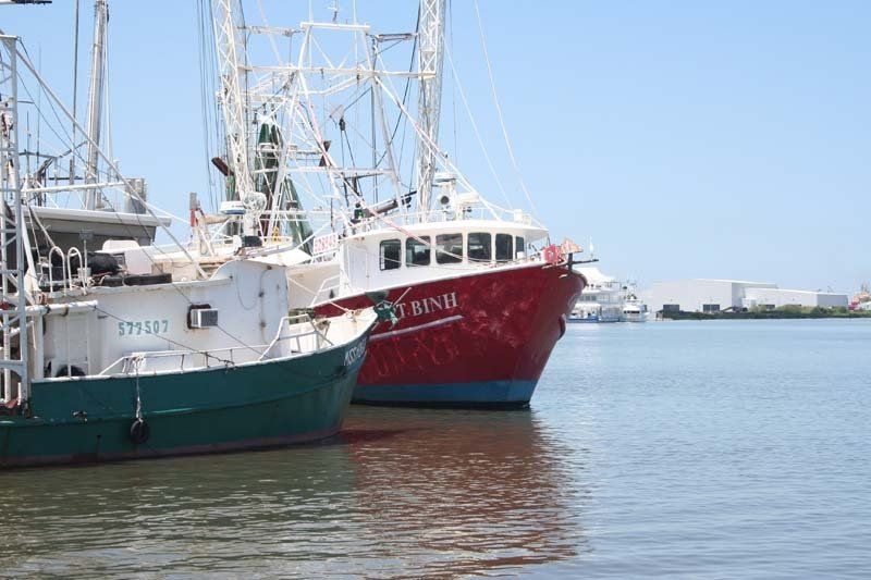 Two boats are docked next to each other in the water.
