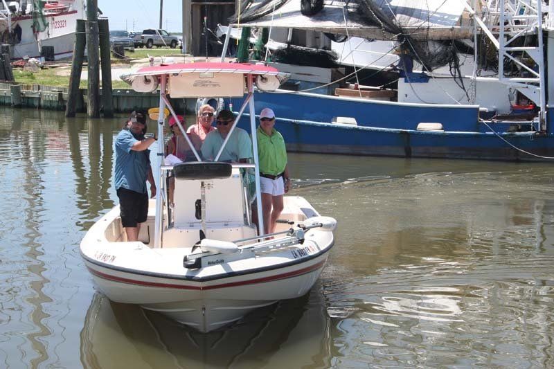 A group of people are standing on a boat in the water