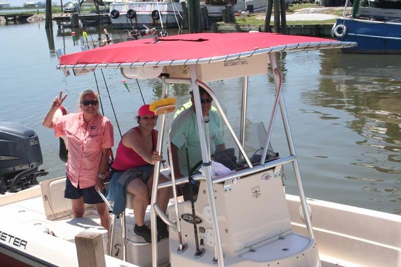 A group of people are sitting on a boat with a red canopy